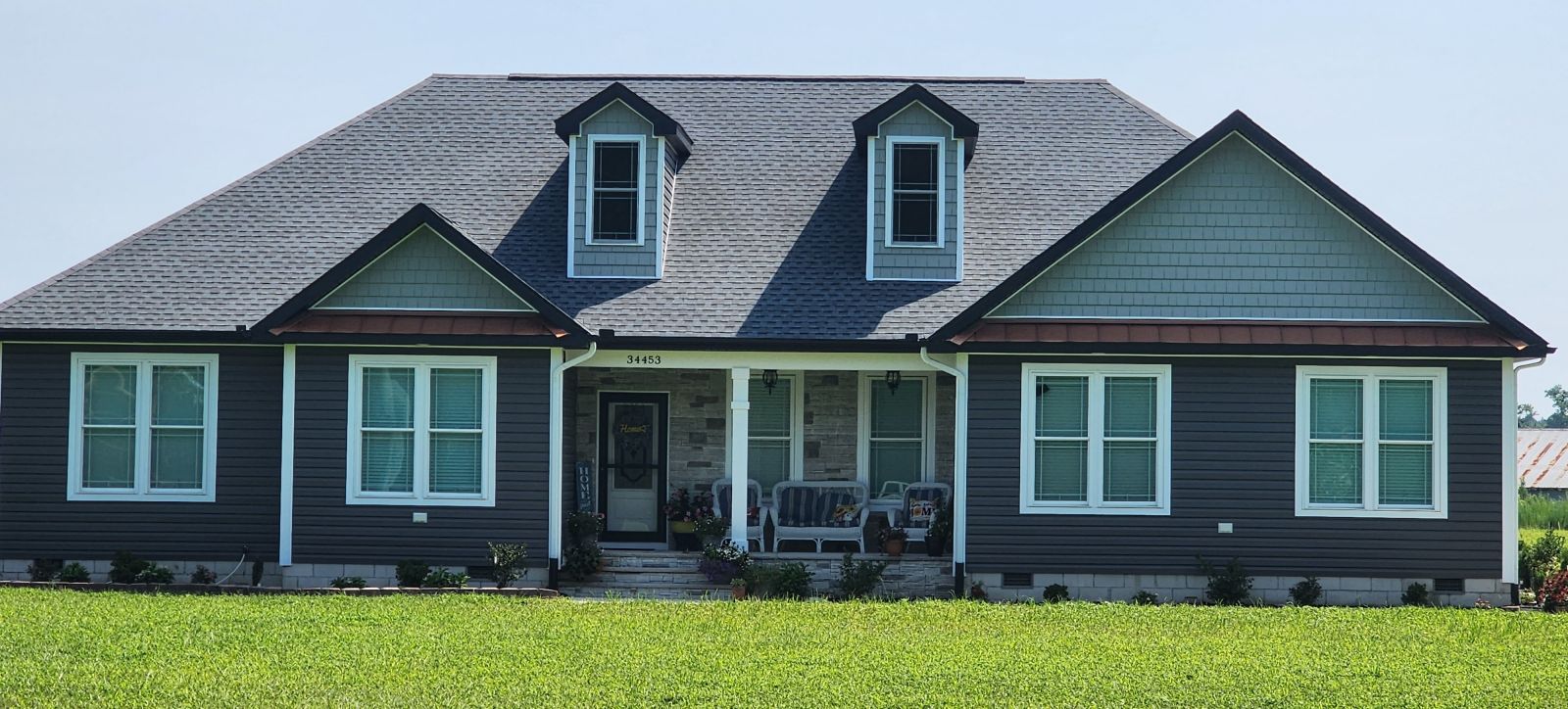 Front view of a new home being constructed and after a new shingles installed by Tyme Builder Inc